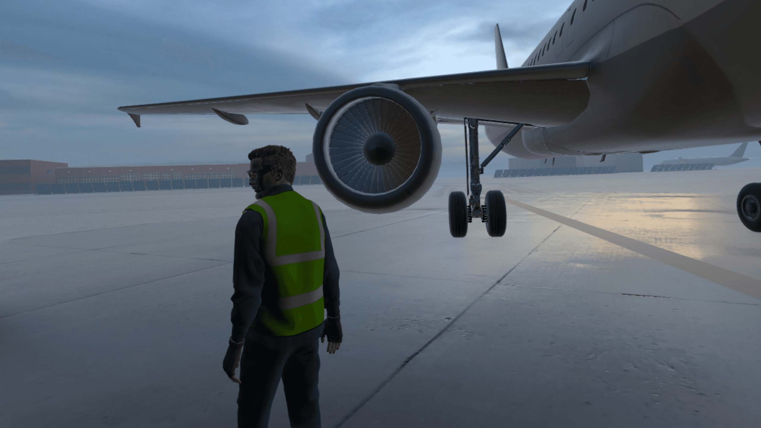 Un placeur en gilet haute visibilité se tient sous l'aile d'un avion sur le tarmac au crépuscule.